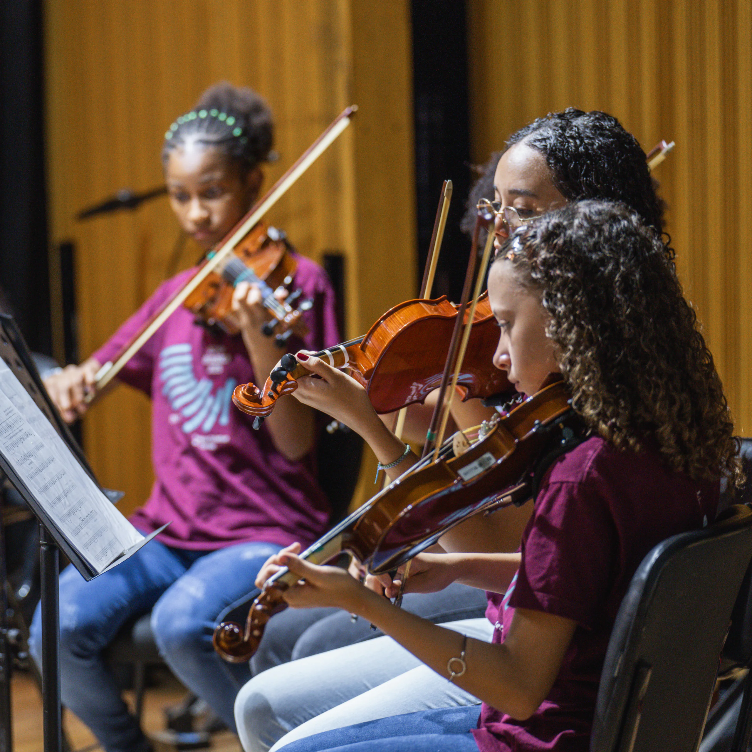 Estudantes e suas famílias conhecem a estrutura da Escola de Música Inhotim e assistem à apresentação de concerto didático com pessoas professoras. 